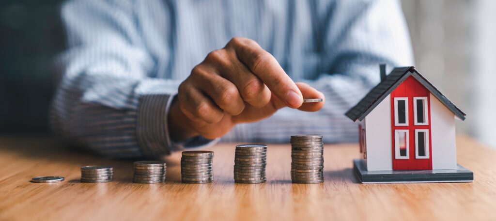 businessman steps coins to find a model house. collecting money to buy a house financial service con